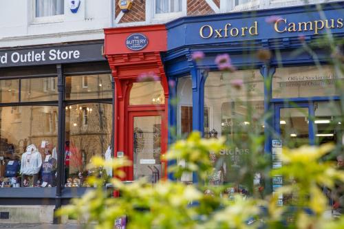 a store with a red door in a street at The Buttery in Oxford
