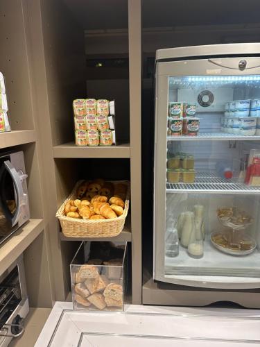 an open refrigerator with bread and a basket of food at Première Classe Paris-Ouest Gennevilliers in Gennevilliers