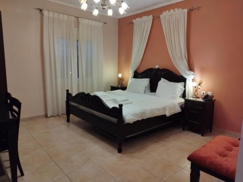 a bedroom with a large black bed with white sheets at Pozar Salt Cave Hotel Spa in Kato Loutraki