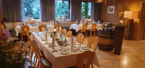 a large dining room with white tables and chairs at Speidel´s BrauManufaktur in Ödenwaldstetten