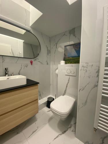 a white bathroom with a toilet and a sink at Nokturno Accomodation in Zagreb