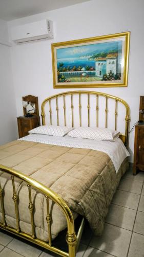 a bed in a bedroom with a painting on the wall at Villa Bella in Noci