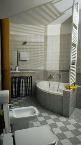a bathroom with a tub and a toilet and a sink at Villa Bella in Noci