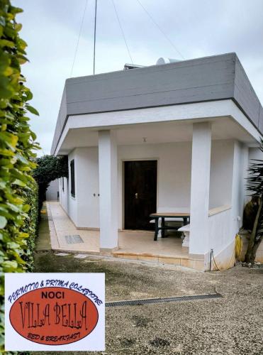 uma pequena casa branca com um sinal em frente em Villa Bella em Noci