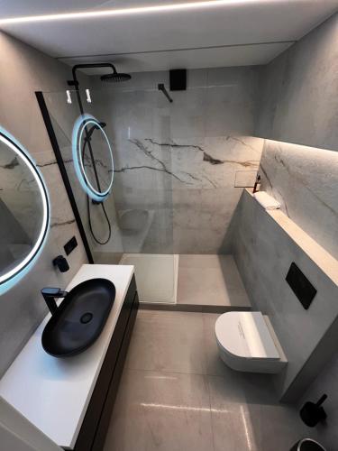 La salle de bains est pourvue d'un lavabo, de toilettes et d'un miroir. dans l'établissement Apartament Konin Makowa, à Konin