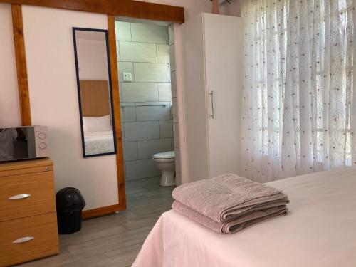 a bedroom with a bed and a bathroom with a toilet at The Affectionate One in Louis Trichardt
