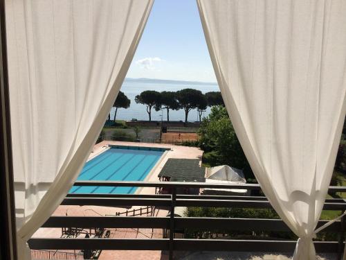 Blick auf den Pool aus dem Fenster in der Unterkunft HA Hotel in Bracciano