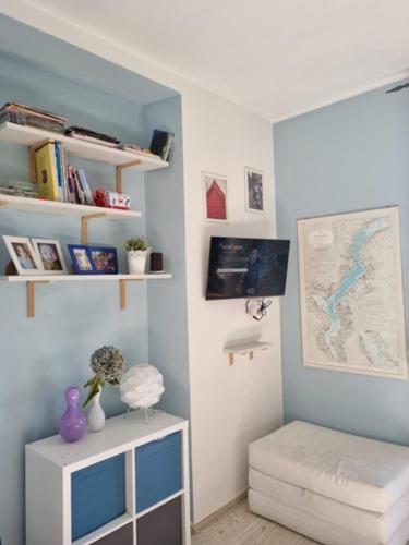 a room with a blue wall with a desk and a shelf at Apartment camelie with private beach in Baveno