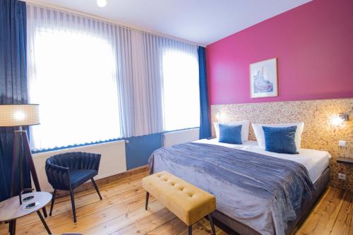 a bedroom with a bed and a pink wall at Boutique Hotel Schwarzer Baer in Lutherstadt Wittenberg