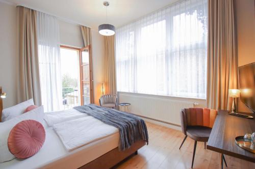 a bedroom with a bed and a large window at Boutique Hotel Schwarzer Baer in Lutherstadt Wittenberg