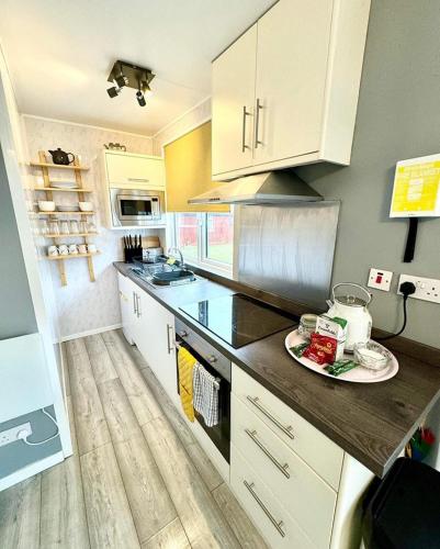 a kitchen with white cabinets and a plate of food on the counter at 247a South Shore Pet friendly in Bridlington