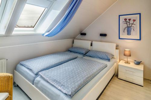 a bedroom with a bed and a window at Ferienhaus Raschke in Norderney
