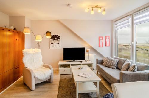 a living room with a couch and a tv at Ferienhaus Raschke in Norderney