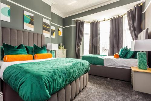 two beds in a room with green and orange at Room 04 - Sandhaven Rooms Triple in South Shields