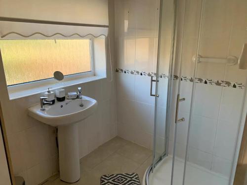 ein Bad mit einem Waschbecken und einer Dusche in der Unterkunft Stunning 3-Bed House in Cheadle in Cheadle