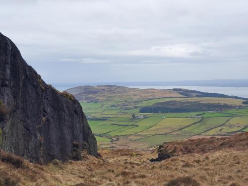 a view of a mountain with green fields and the ocean at Carlingford Mountain Farm in Dundalk