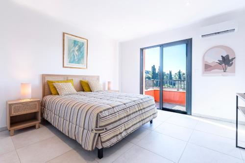 une chambre blanche avec un lit et une grande fenêtre dans l'établissement Pandora 6 personnes magnifique apparemment avec piscine dans la résidence, à Ajaccio