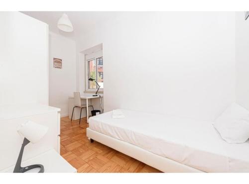 a white bedroom with a bed and a desk at HOUZE_Central Lisbon 4 room flat in Lisbon