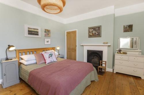 a bedroom with a large bed and a fireplace at Minster House - Group Hot Tub in York