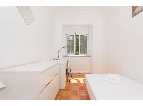 a white kitchen with a sink and a window at HOUZE_Central Lisbon 4 room flat in Lisbon