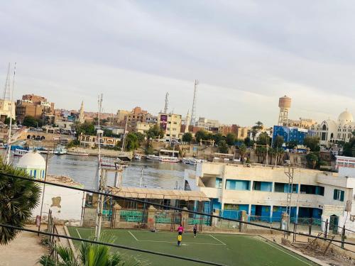 two people playing tennis on a tennis court next to a river at SmSm Kato in Aswan