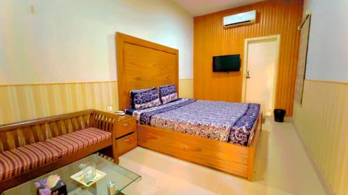 a small bedroom with a bed and a couch at Best Couple Coprtive Guest House in Karachi