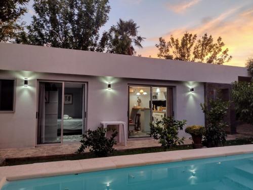 a white house with a swimming pool in front of it at Colonia in Colonia del Sacramento