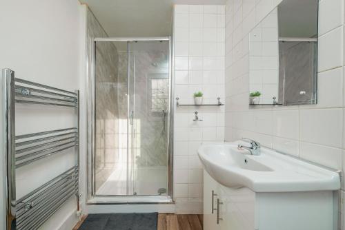 ein weißes Bad mit einer Dusche und einem Waschbecken in der Unterkunft Uksas Stunning one bedroom Flat Free Parking in London