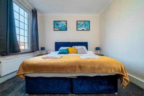 a bedroom with a large bed with yellow and blue sheets at Uksas Stunning one bedroom Flat Free Parking in London