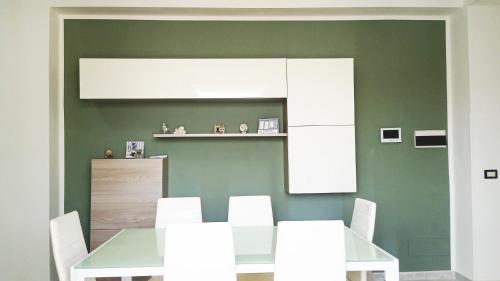 uma sala de jantar com uma mesa e cadeiras brancas em Terrazza Bianca em Vittoria