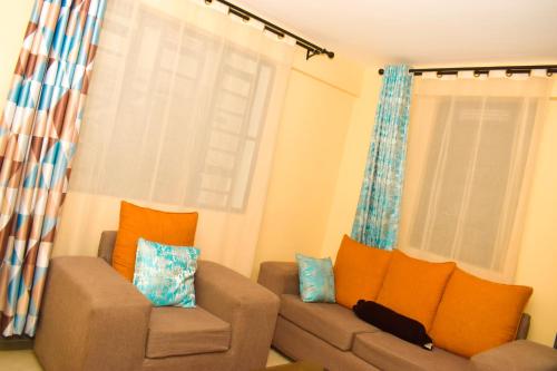a living room with a couch and two windows at Lighthomes Two Bedroom Thika CBD in Thika