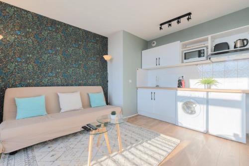 un salon avec un canapé et une machine à laver dans l'établissement Lille Gare - 2 pers incredible view on Lille !, à Lille