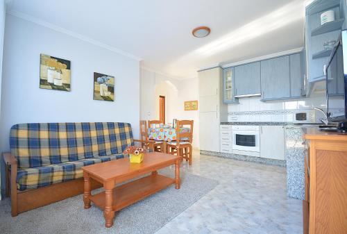 a living room with a couch and a table at Apartamentos en Playa de Montalvo in Sanxenxo
