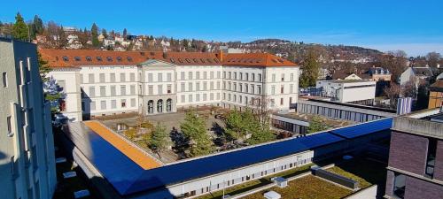 einen Ausblick über ein großes weißes Gebäude in der Unterkunft Ruhige, Neue Dachwohnung an Altstadt, Nahe Messe in St. Gallen