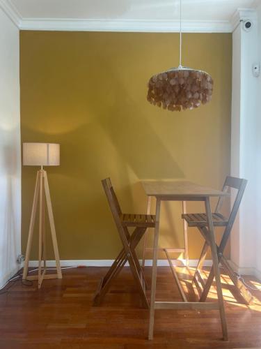 stół, krzesła i lampka w pokoju w obiekcie Impact Beach House w mieście Estoril