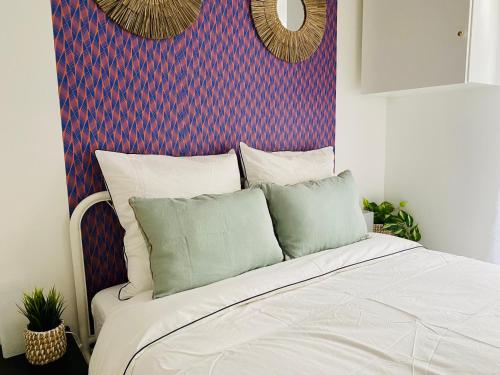 - une chambre avec un lit blanc et un mur coloré dans l'établissement Vincennes - Beautiful renovated architect studio, à Vincennes
