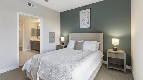- une chambre avec un lit et 2 tables de nuit avec des lampes dans l'établissement Landing Modern Apartment with Amazing Amenities (ID5374X57), à San Diego