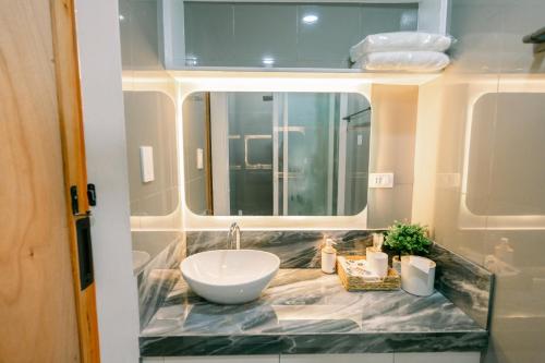 a bathroom with a sink and a mirror at Frost at Air Residences Makati in Manila