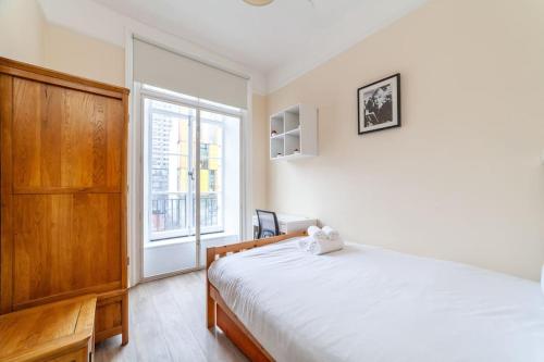 a bedroom with a large white bed and a window at Spacious & Central 3-bed flat by popular Waterloo! in London