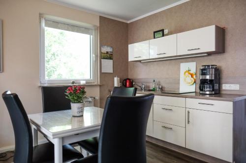 cocina con mesa, sillas y ventana en Ferienwohnung FANNYS, en Bad Sachsa