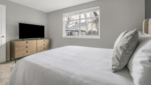 a white bedroom with a bed and a television at Landing Modern Apartment with Amazing Amenities (ID1274X054) in Vancouver