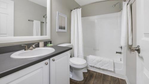 a white bathroom with a sink and a toilet at Landing Modern Apartment with Amazing Amenities (ID1274X054) in Vancouver