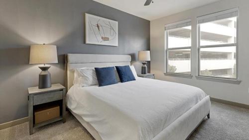 a bedroom with a bed with blue pillows and a window at Landing Modern Apartment with Amazing Amenities (ID1721X12) in Fort Worth