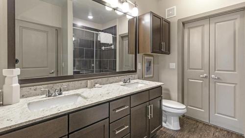 a bathroom with a sink and a toilet and a mirror at Landing Modern Apartment with Amazing Amenities (ID1721X12) in Fort Worth