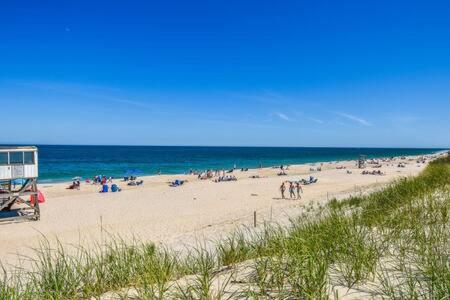 a group of people on a beach near the ocean at 1 min drive to Rock Harbor 2 min to Town in Orleans