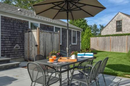 a table and chairs with an umbrella on a patio at 1 min drive to Rock Harbor 2 min to Town in Orleans