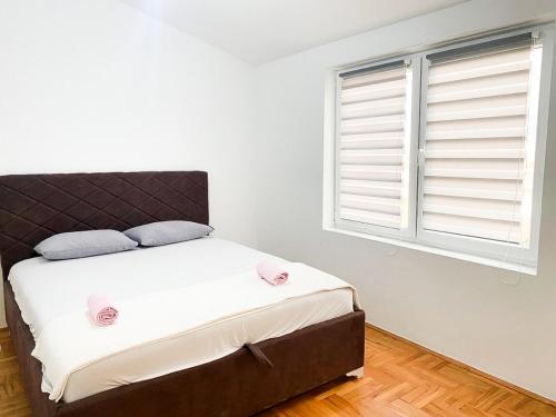 Schlafzimmer mit einem Bett und einem großen Fenster in der Unterkunft Silver Apartment with private garage in Bar