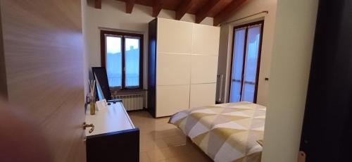 a bedroom with a bed and a desk with a television at Appartamento 93 di Andrea sonzogni in Castelleone