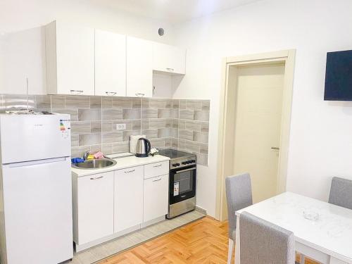 a kitchen with white cabinets and a white refrigerator at Silver Apartment with private garage in Bar