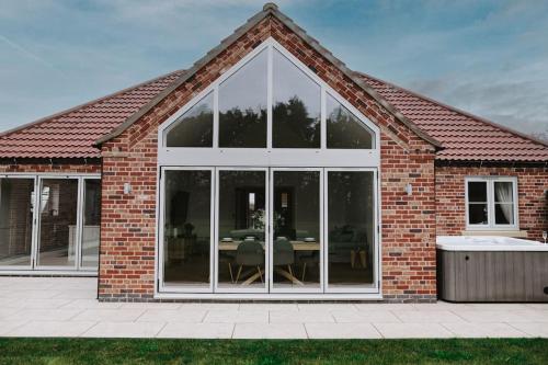 a brick house with a large glass door at Woodhaven Stays in Scredington